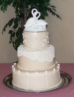 Contrasting details in butter cream filigree topped classic love swans