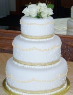 Stacked rolled fondant wedding cake with golden pearl details in buttercream